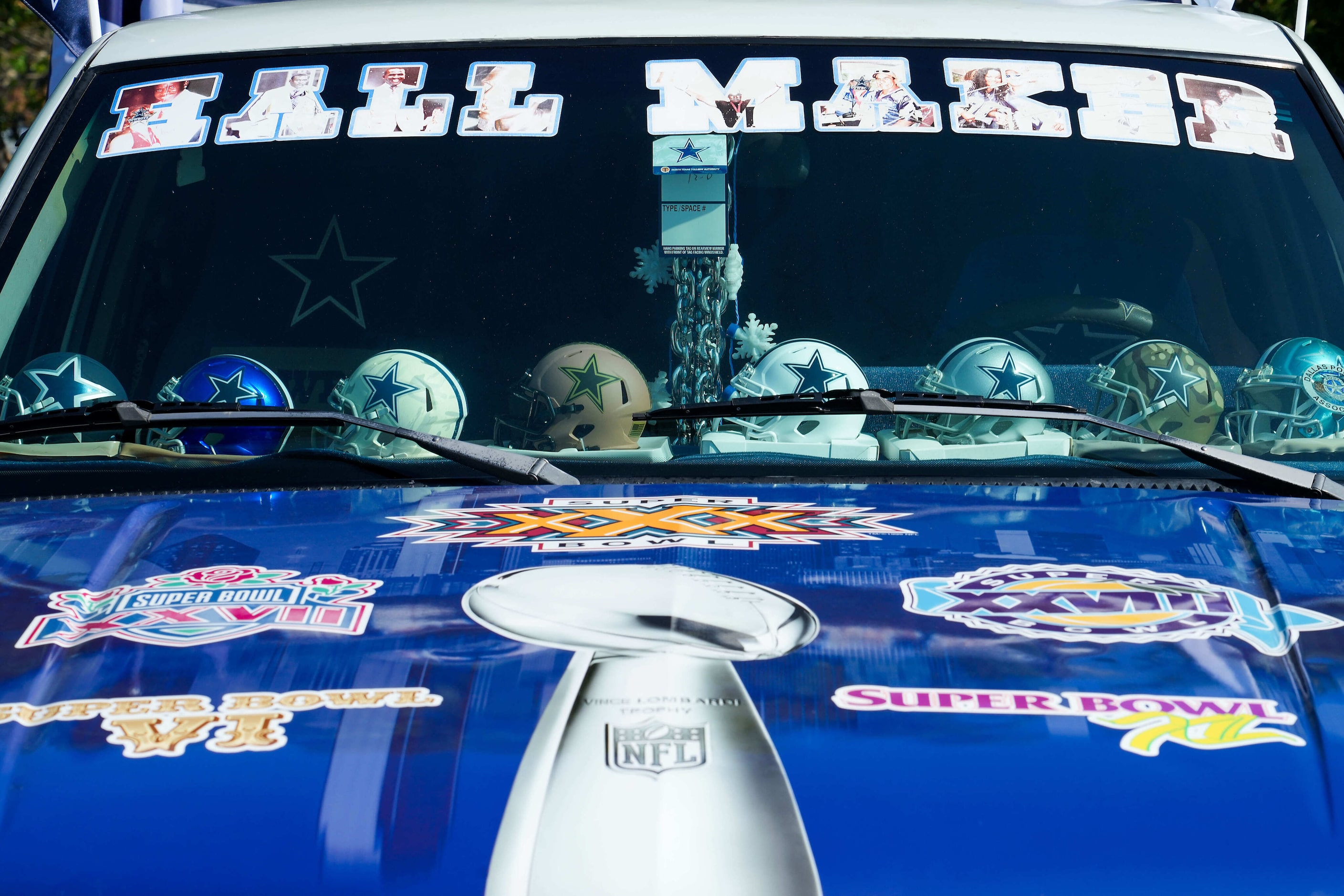 A Dallas Cowboys fans’ dashboard is covered Cowboys helmets while tailgating before an NFL...