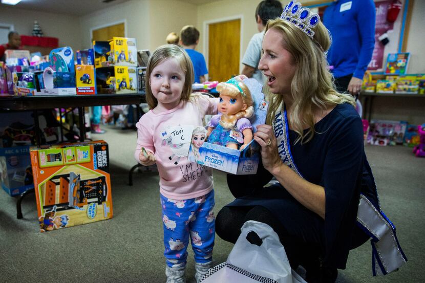 Victoria Carpenter, 3, shows her baby doll to Mrs. Texas Kim Bader during The Big Christmas...