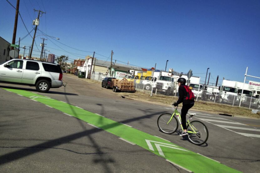 A bicyclist makes her way across Main Street from Hill Avenue using new bike lanes and...