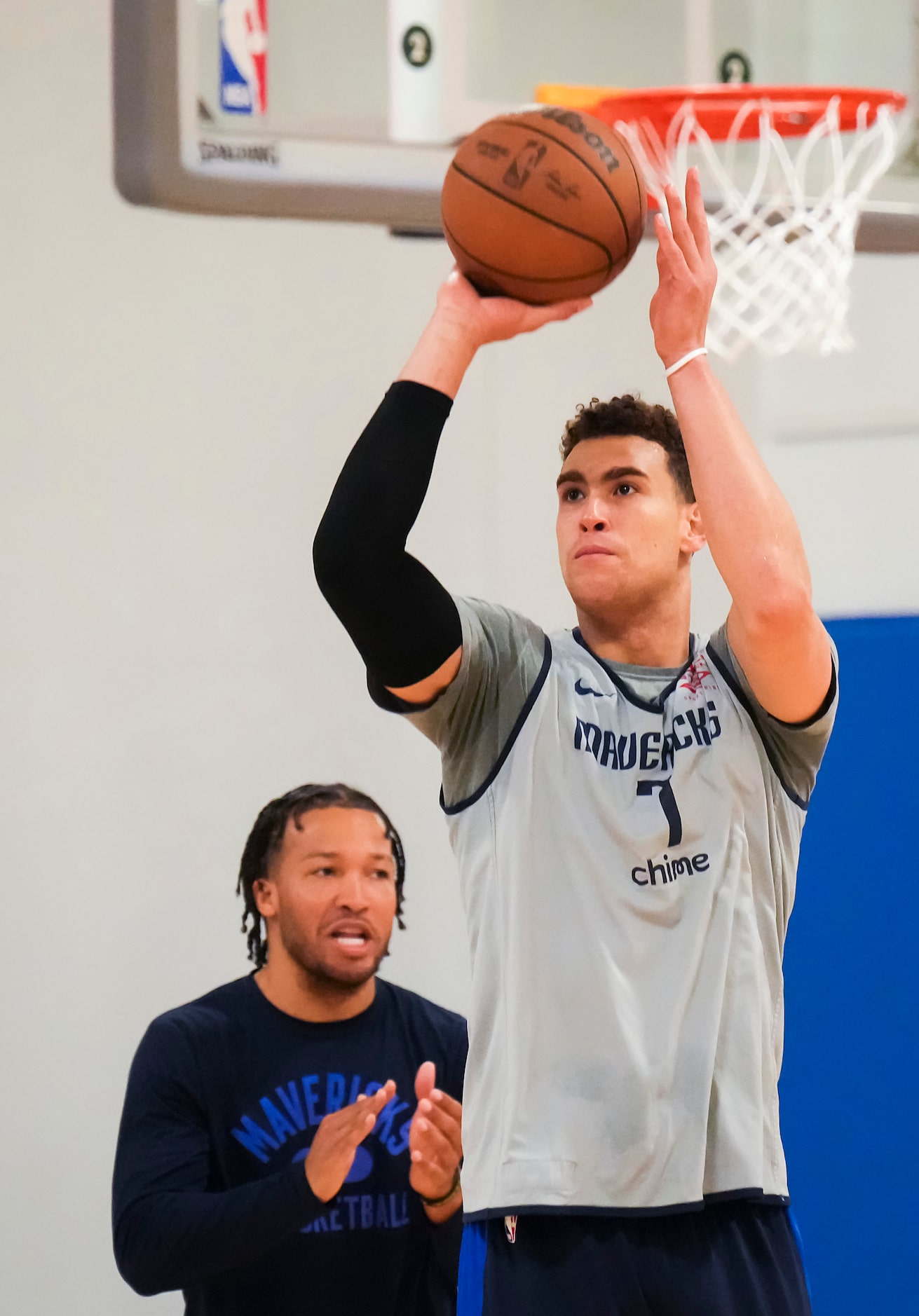 Dallas Mavericks center Dwight Powell (7) shoots while guard Jalen Brunson looks on as the...