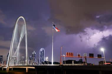 Lightning from a passing storm strikes south of the downtown Dallas skyline and the Margaret...