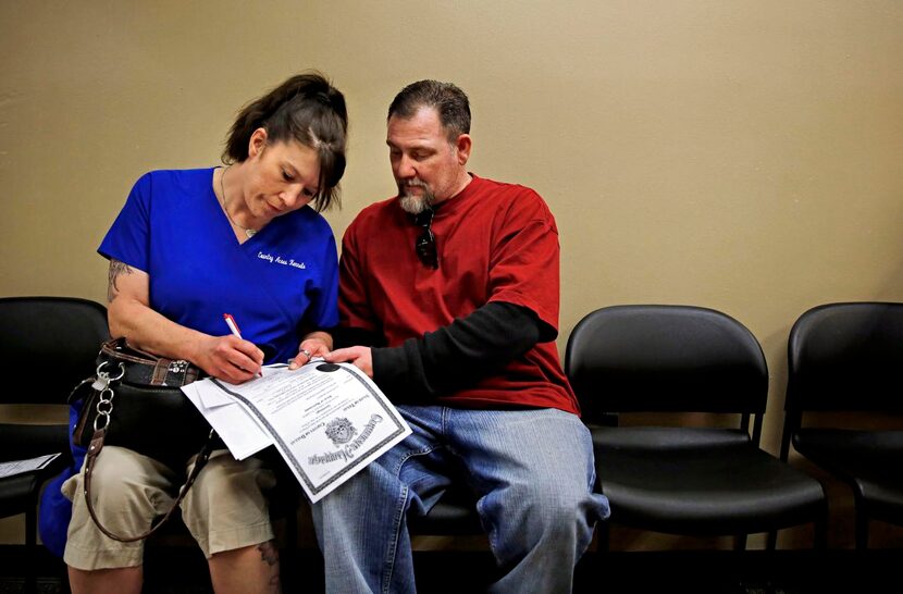 
Michelle Dempsey and her new husband, Lloyd Dempsey, filled out paperwork at the Dallas...