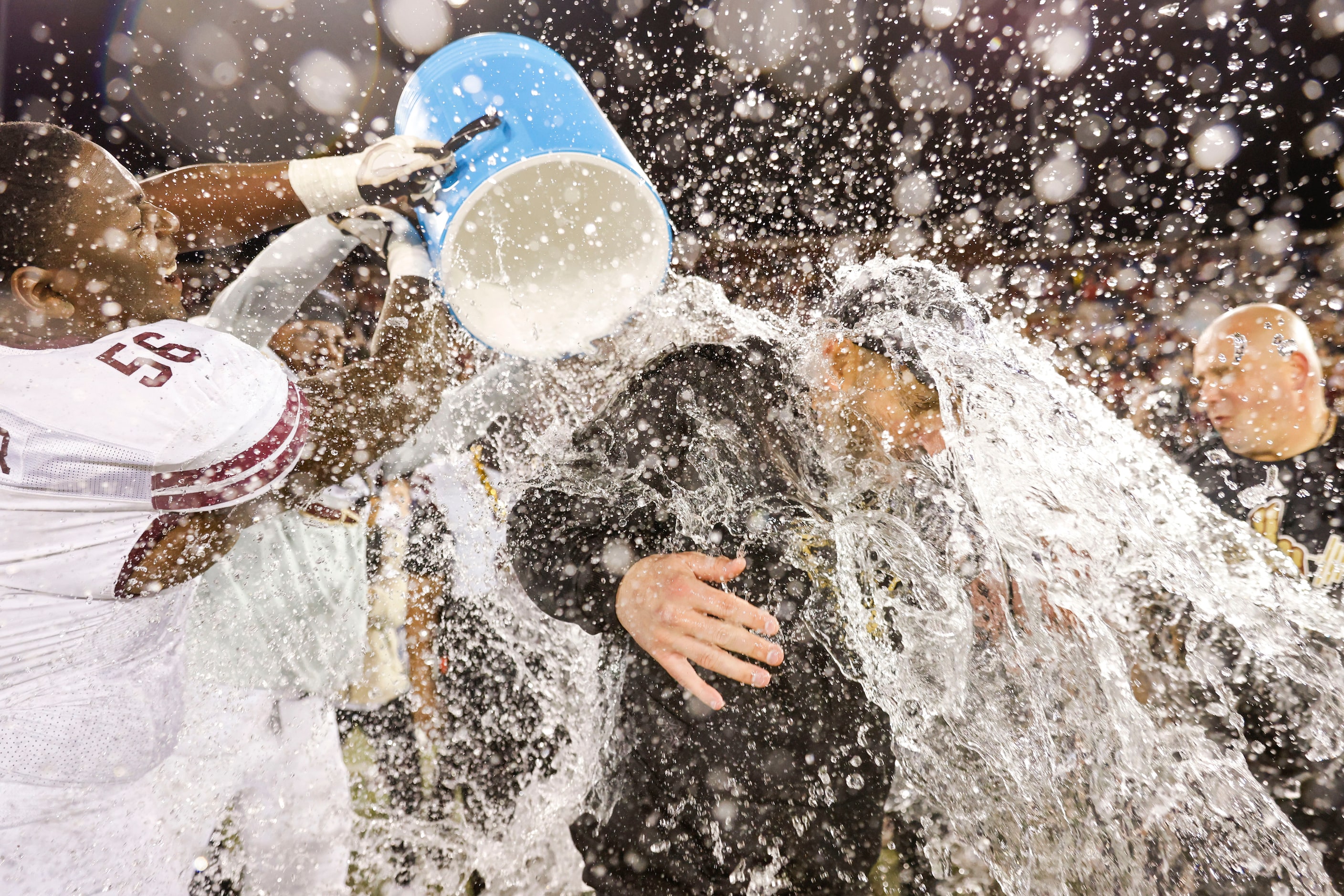 Texas State head coach GJ Kinne is doused by water ahead of his team’s victory in the First...