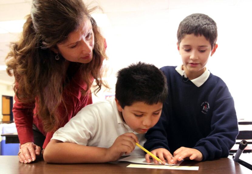 Zach Thibodeaux (right) and his aunt, Martha McWilliam, assist Justin Montenegro in reading...