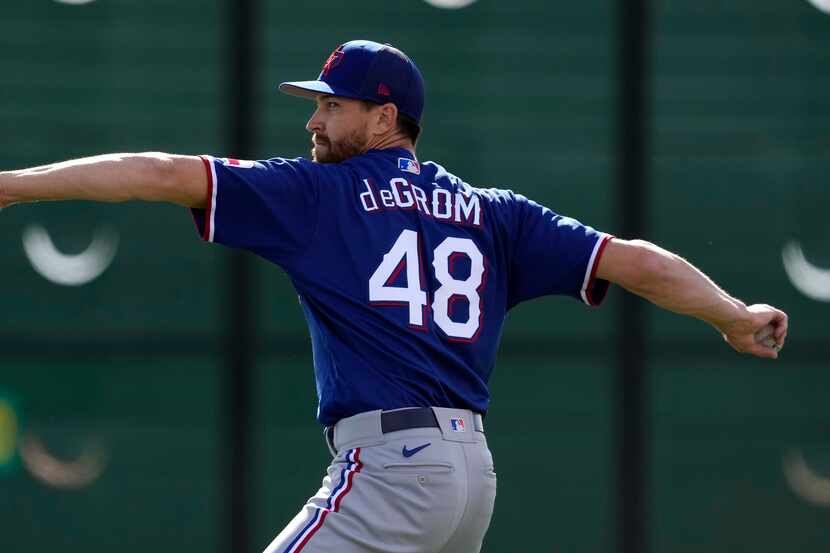 Texas Rangers pitcher Jacob deGrom throws during spring training baseball practice Sunday,...