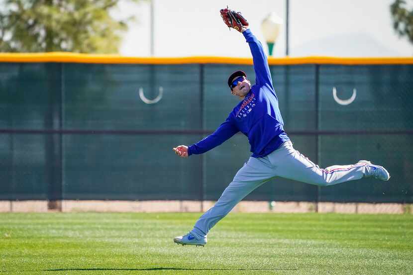 El jardinero de los Texas Rangers, Scott Heineman, realiza una atrapada durante los...