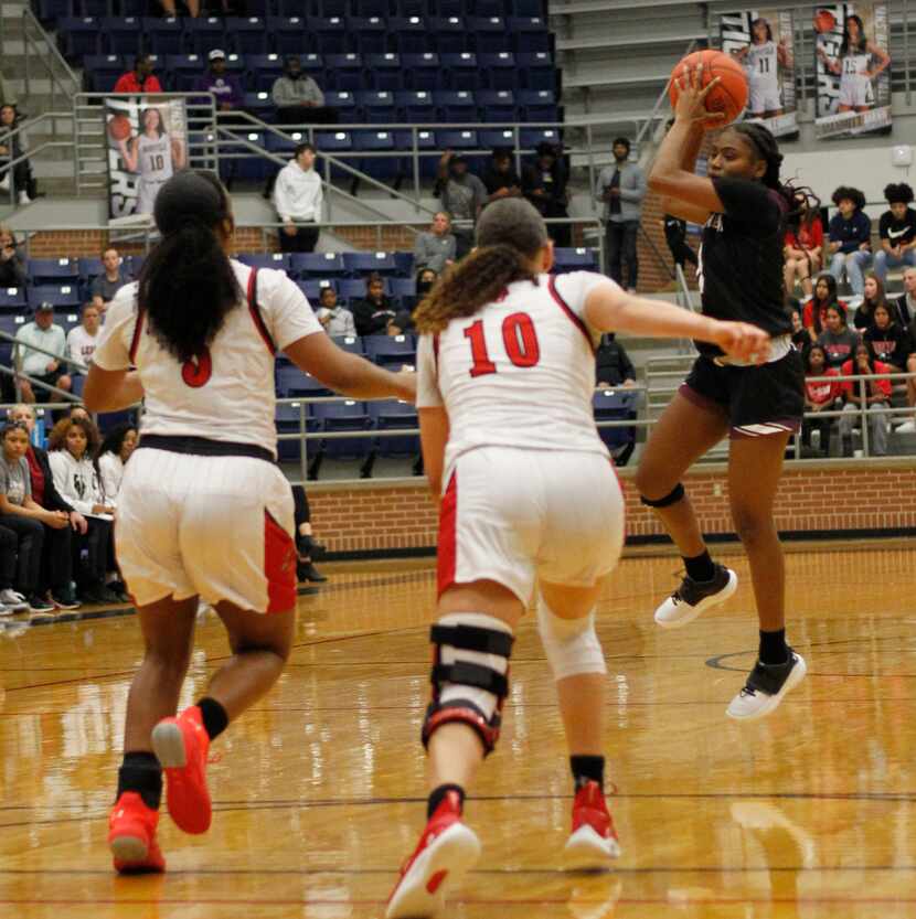Mansfield Timberview guard Kyla Smith (11) leaps to pull in a high pass as she is defended...
