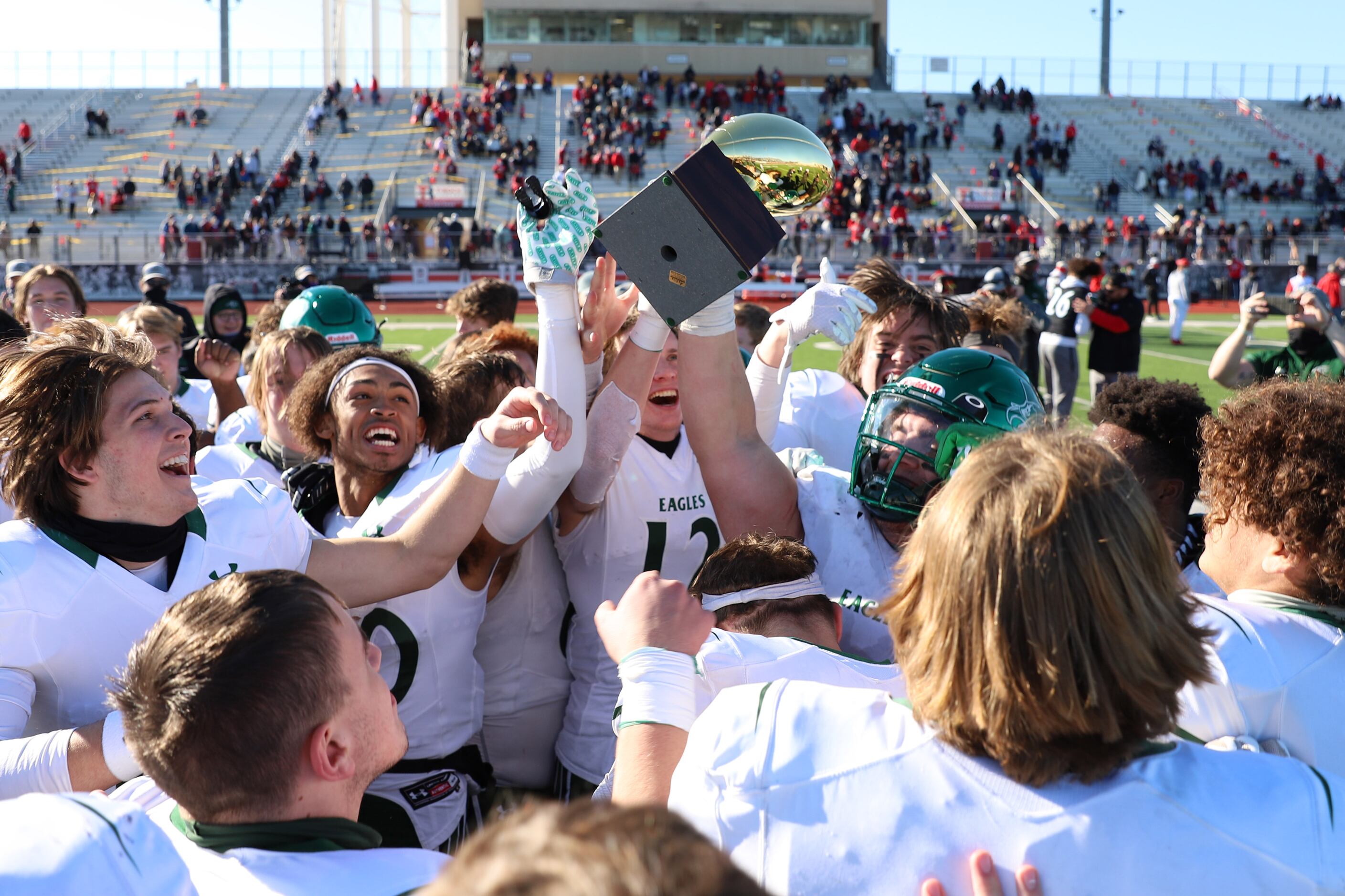 Prosper players celebrate with the trophy after a bi-district playoff win against Flower...