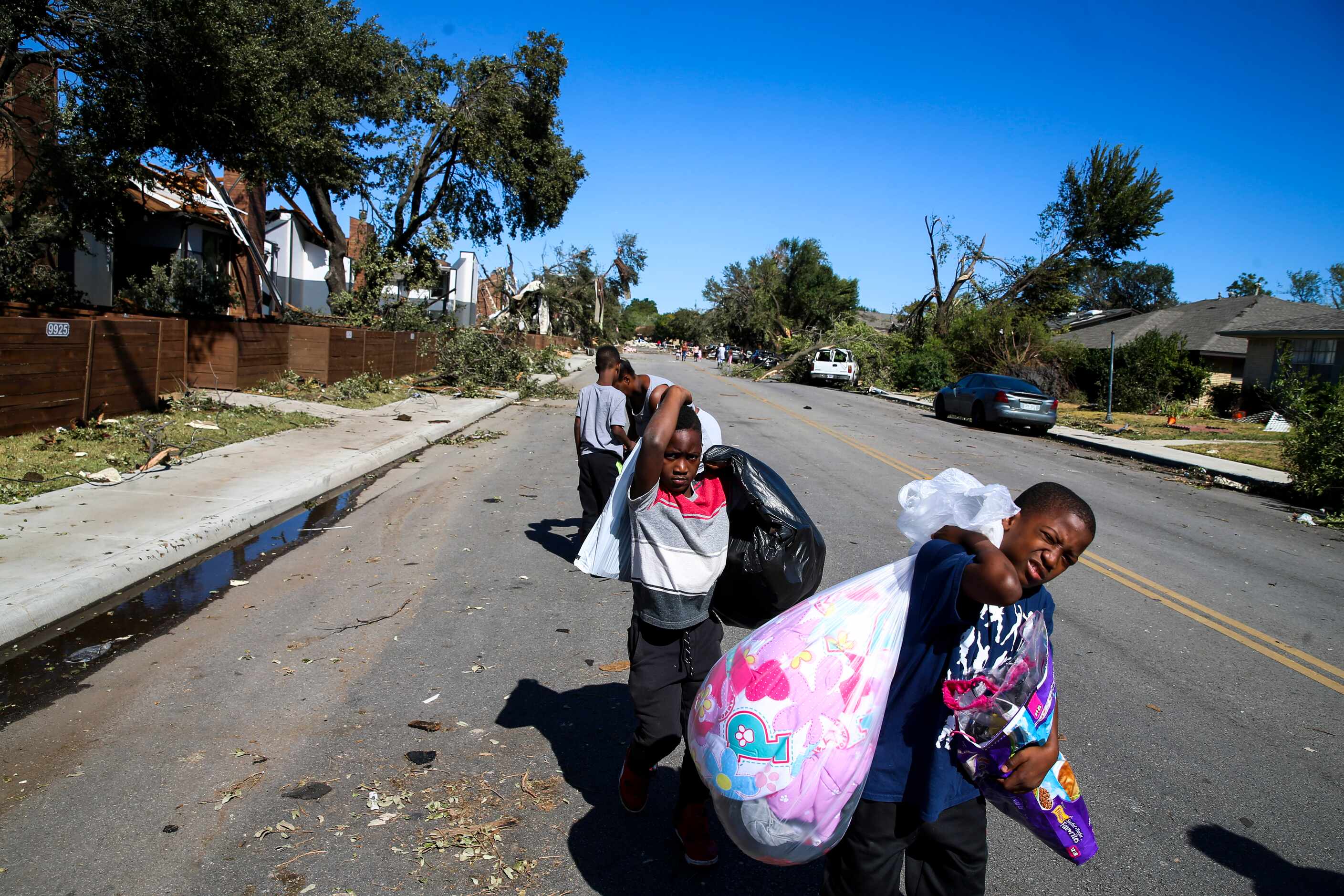 Ja’Marcus jones, 9, followed by Kalin Gassaway, 7, move their belonging to go stay with...