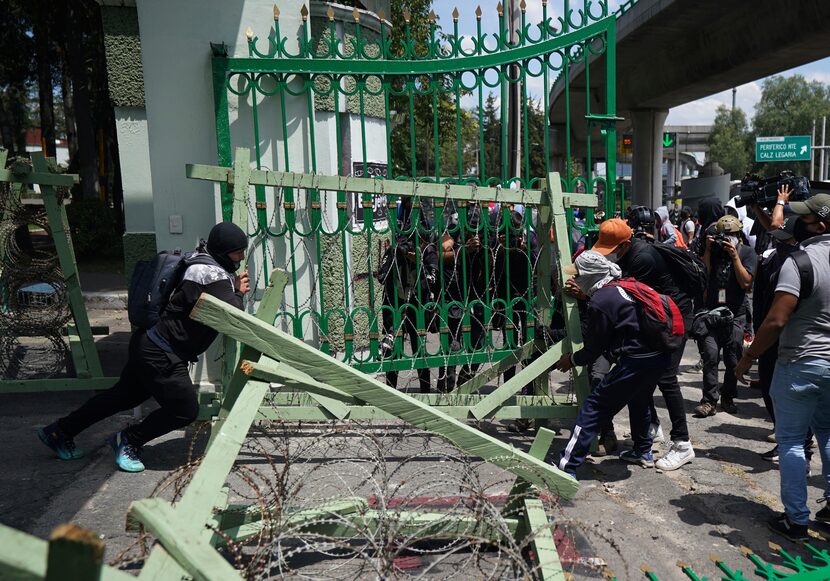 Manifestantes que protestan por la desaparición de 43 estudiantes universitarios retiran las...