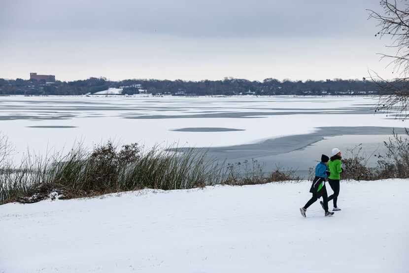 A couple of women jogged Feb. 17 on the snow that fell during an overnight storm at White...