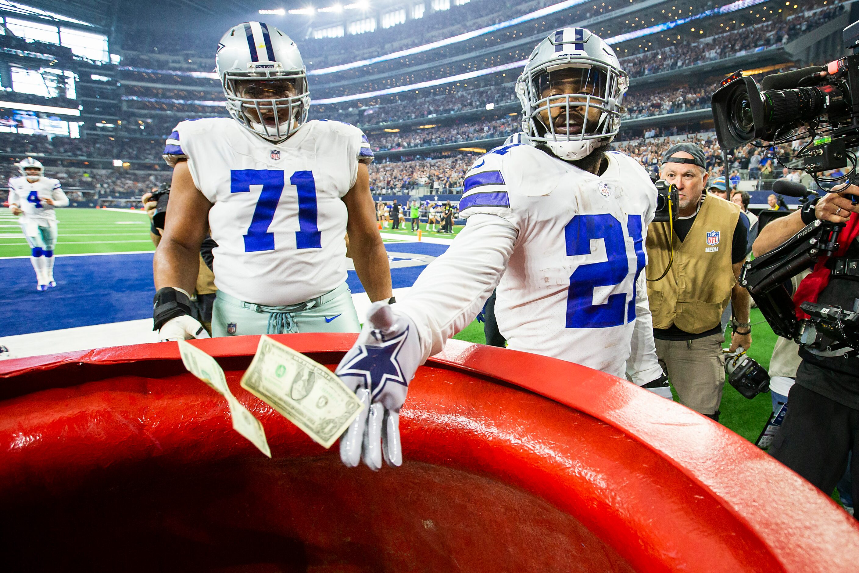 Dallas Cowboys running back Ezekiel Elliott (21) drops $21 into the Salvation Army kettle...