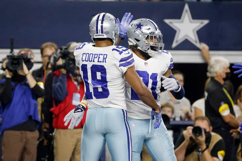 Dallas Cowboys wide receiver Amari Cooper (19) congratulates running back Ezekiel Elliott...