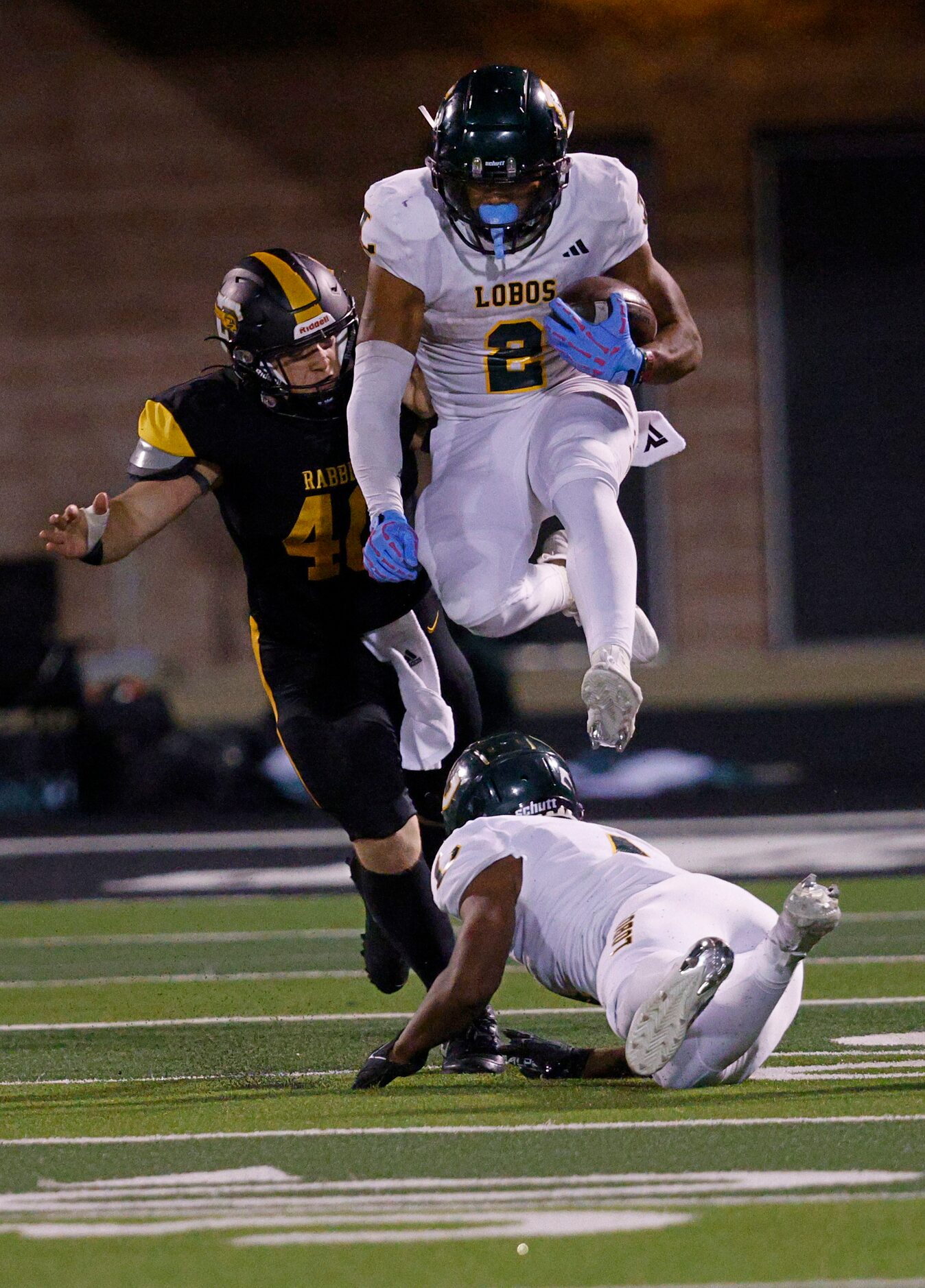 Longview's Taylor Tatum (2) jumps over Longview's Buster Mumphrey (4) as Forney's Landry...