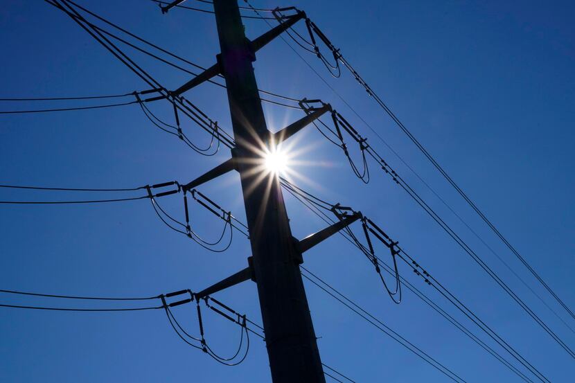 Blue skies and sunshine are seen behind Oncor electric transmission lines as North Texas...