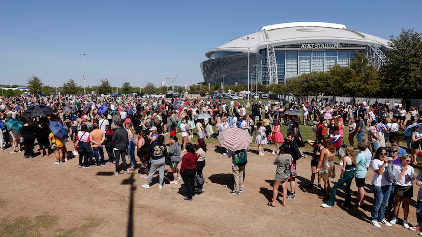 Fans wait in line to buy merchandise before a Taylor Swift Eras Tour concert at AT&T Stadium...