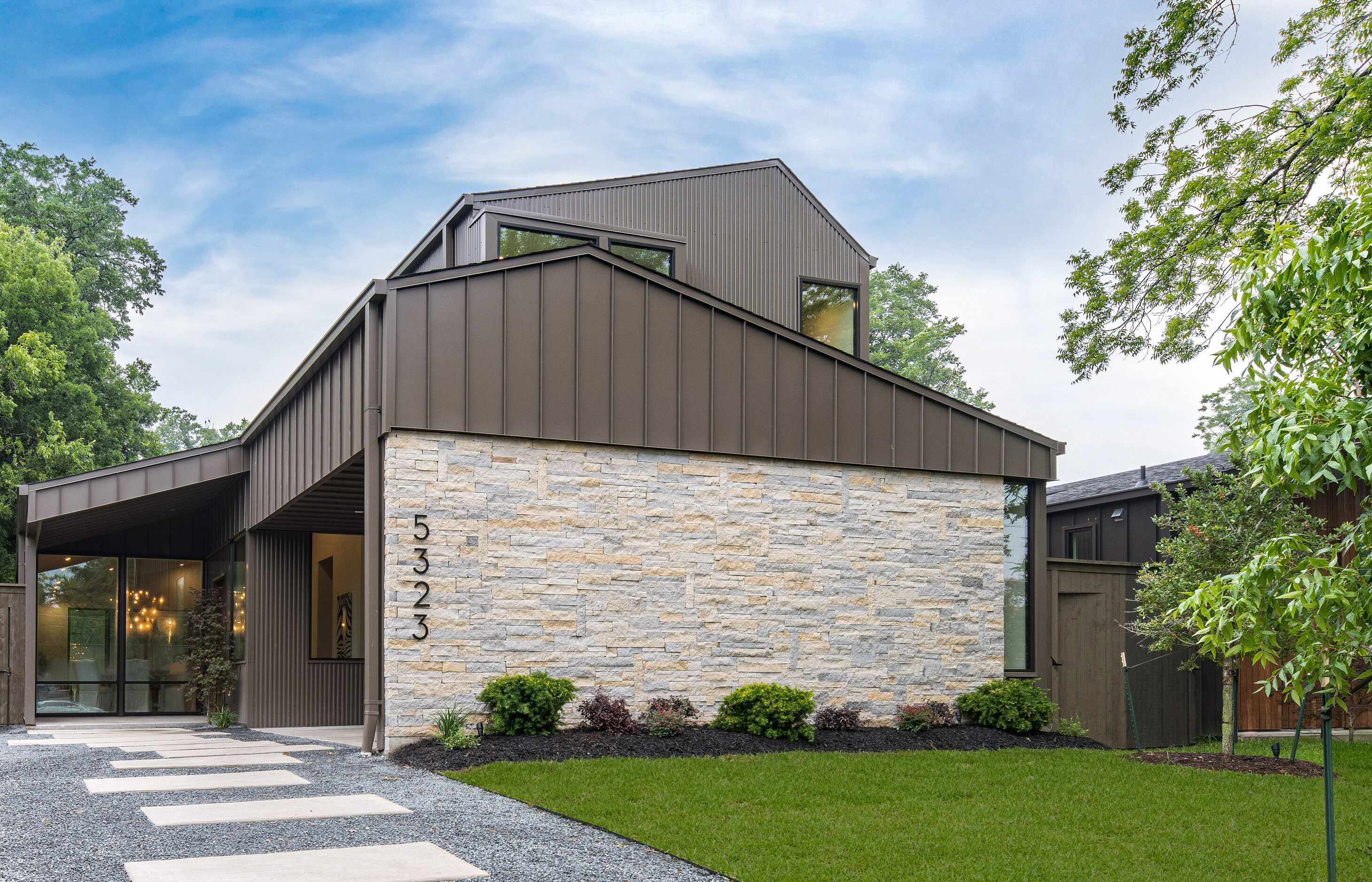 Contemporary home exterior with medal siding and stone