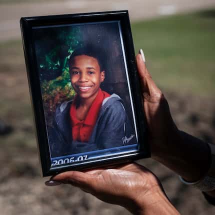 Donna Fields, 47, holds a photo of her son Marcus Bell Jr., who says Rush raped him when he...