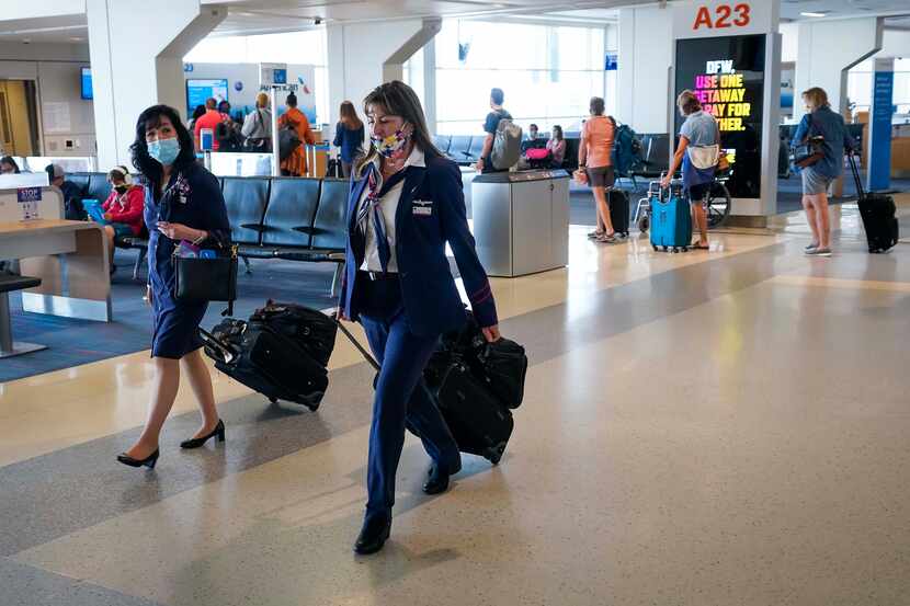 American Airlines flight attendants walk along a concourse at DFW International Airport.