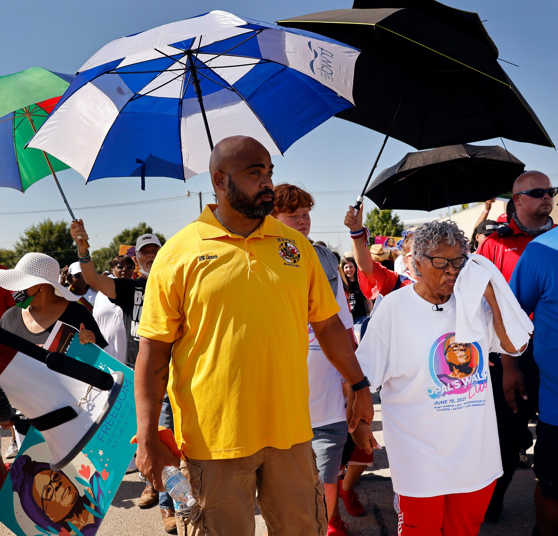 Opal Lee, right, had a shaded escort as she trekked down Evans Ave headed for downtown Fort...