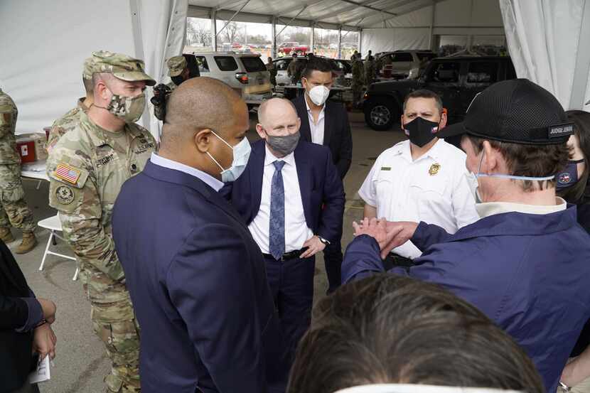 John Whitley, secretario interino del ejército (centro), platica con el juez del condado...