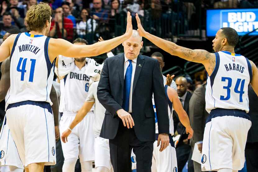 Dirk Nowitzki and Devin Harris are high-fiving, not slapping coach Rick Carlisle on the...