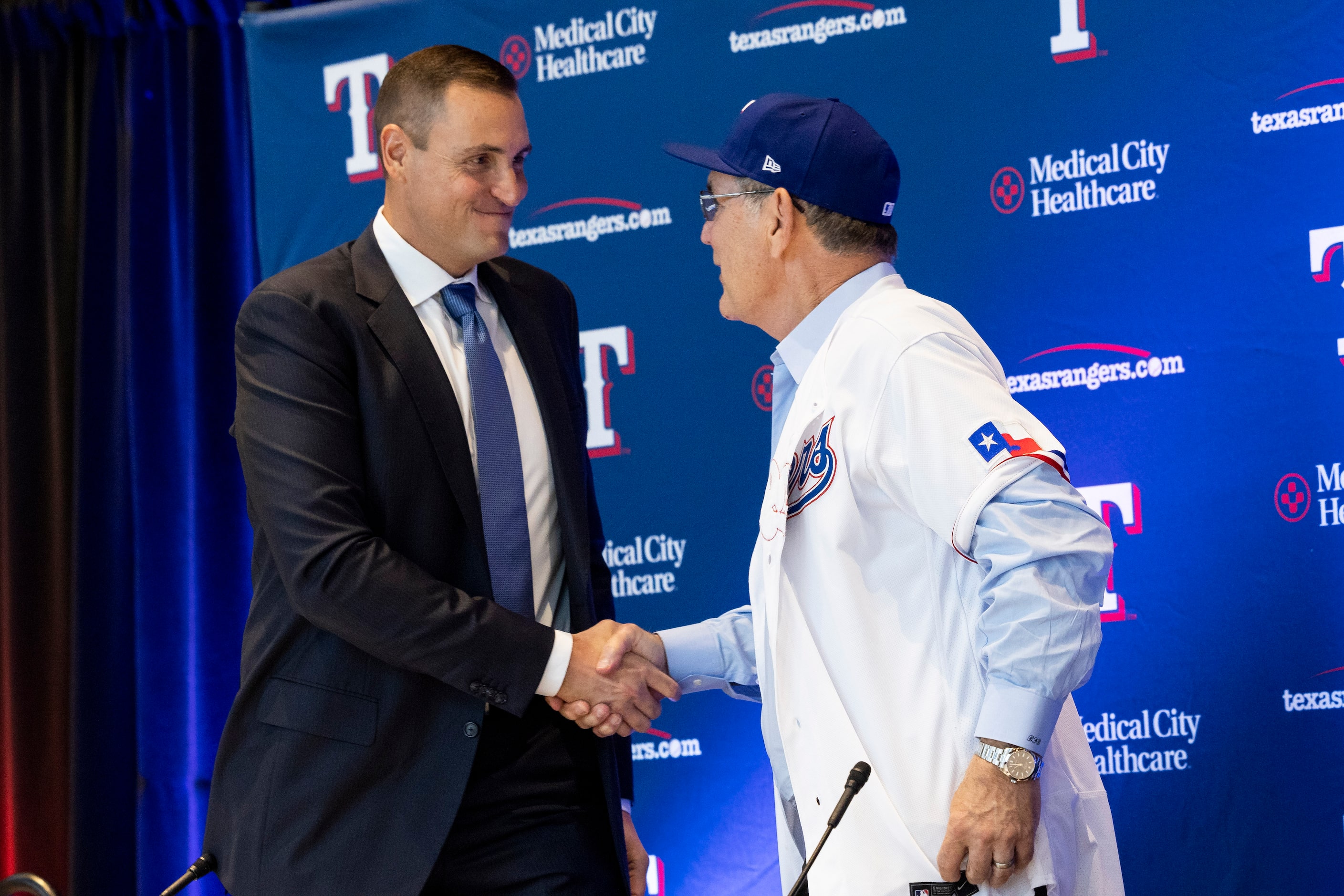 Chris Young (left), the team's executive vice president and general manager, shakes hands...