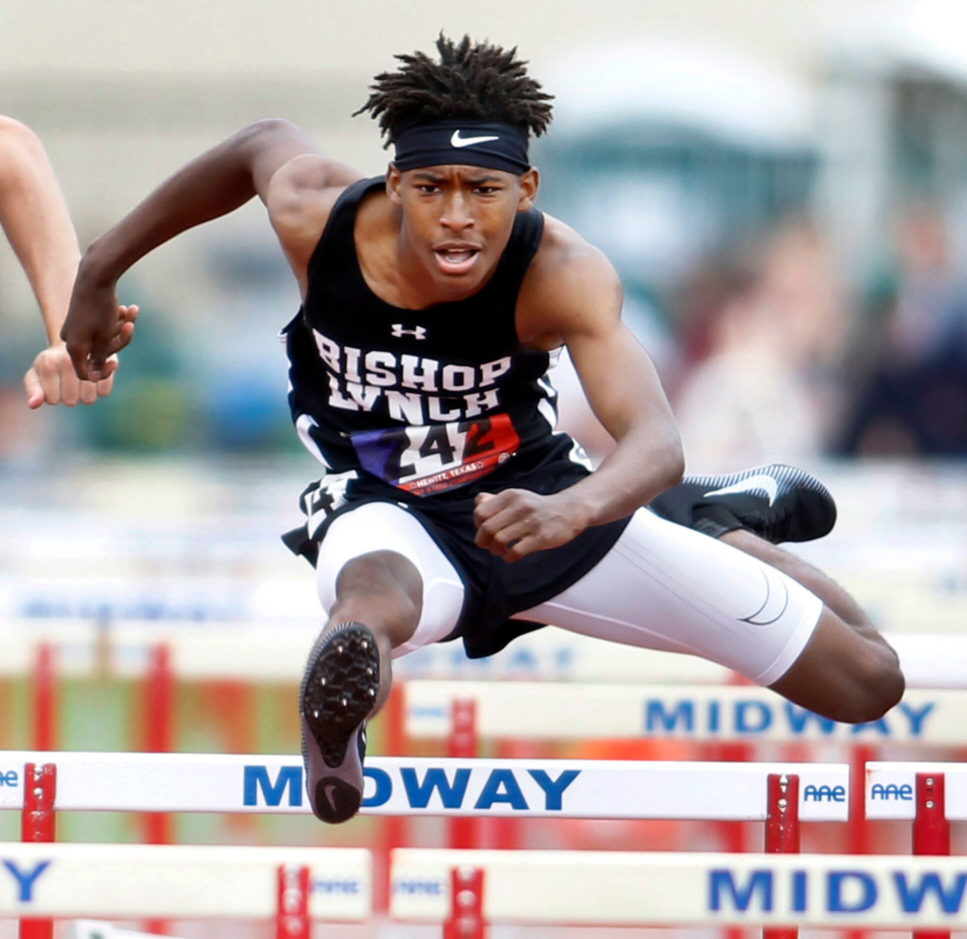 Dallas Bishop Lynch hurdler Jeremiah Williams clears a hurdle enroute to his first place...