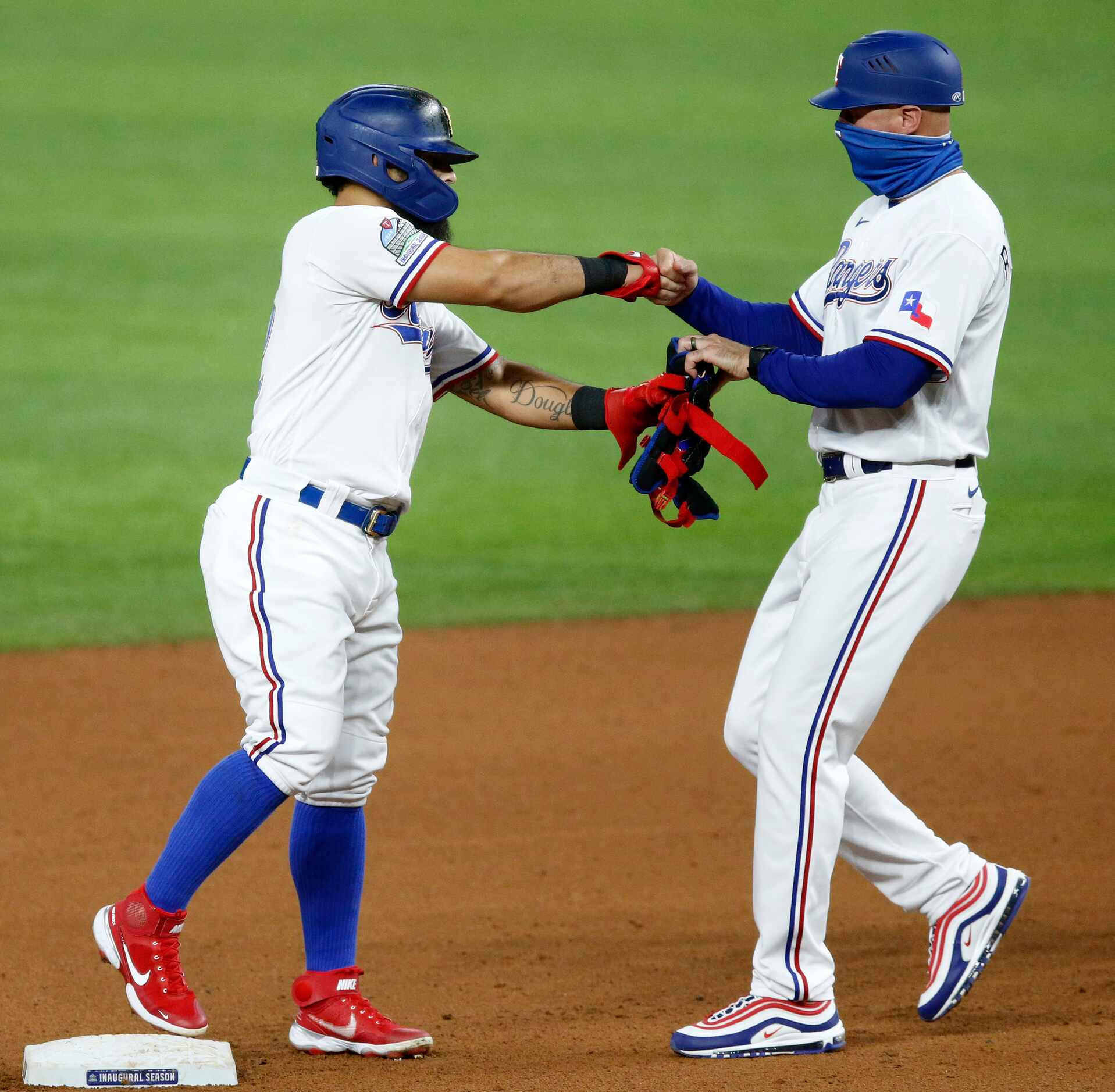 Texas Rangers first base coach Corey Ragsdale gives Rougned Odor (12)  a fist bump after his...