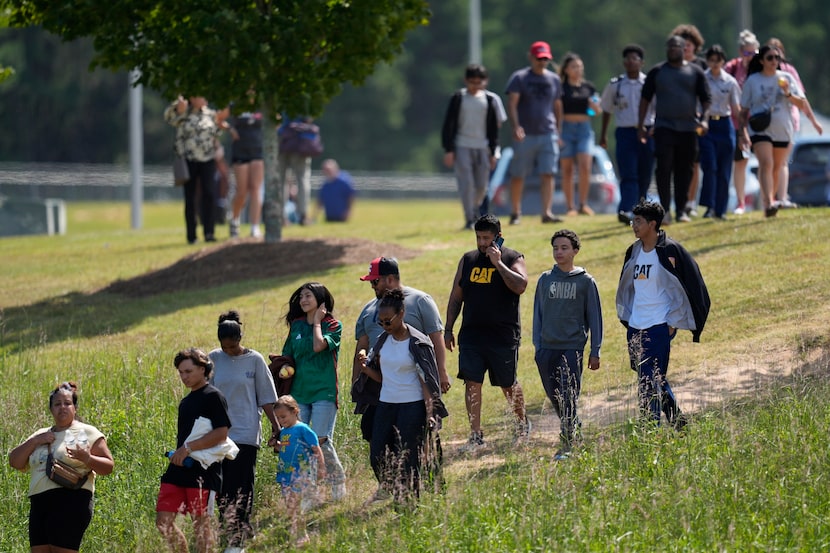 Students and parents walk off campus at Apalachee High School, Wednesday, Sept. 4, 2024, in...