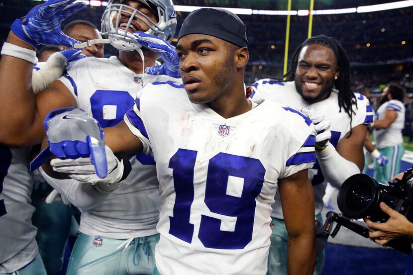 Dallas Cowboys wide receiver Amari Cooper (19) is congratulated by teammates after scoring...