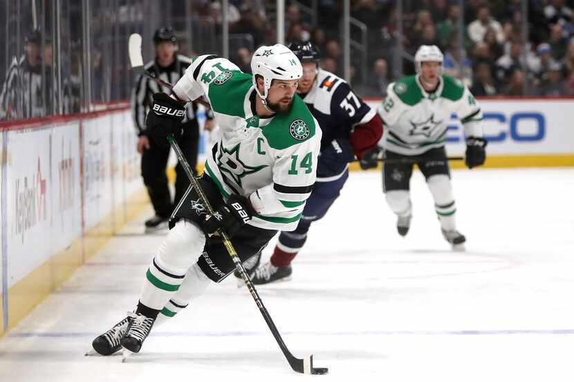 DENVER, CO - NOVEMBER 24:  Jamie Benn #14 of the Dallas Stars advances the puck against the...