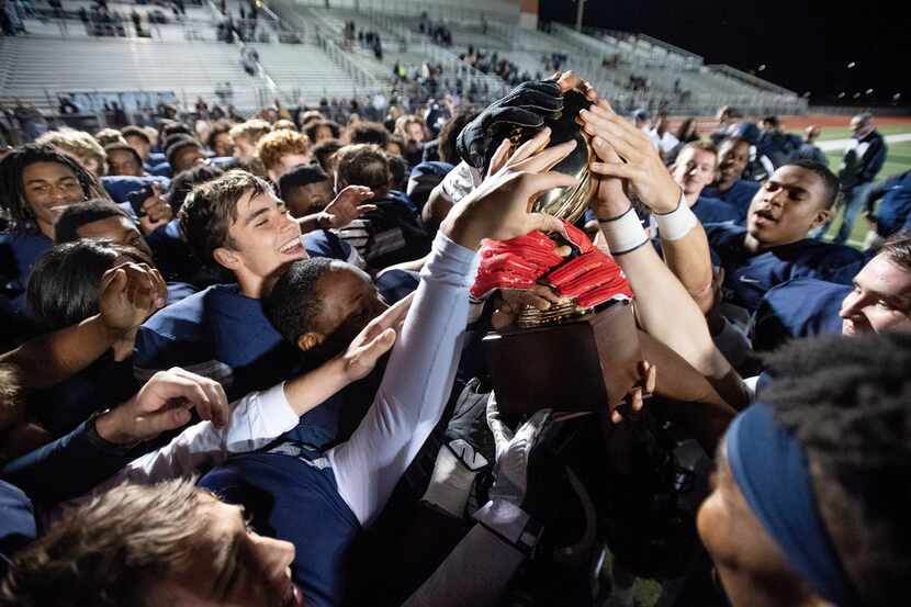 Frisco Lone Star players hoist their trophy after defeating Mansfield Legacy 41-6 in a...