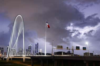 Lightning from a passing storm strikes south of the downtown Dallas skyline and the Margaret...