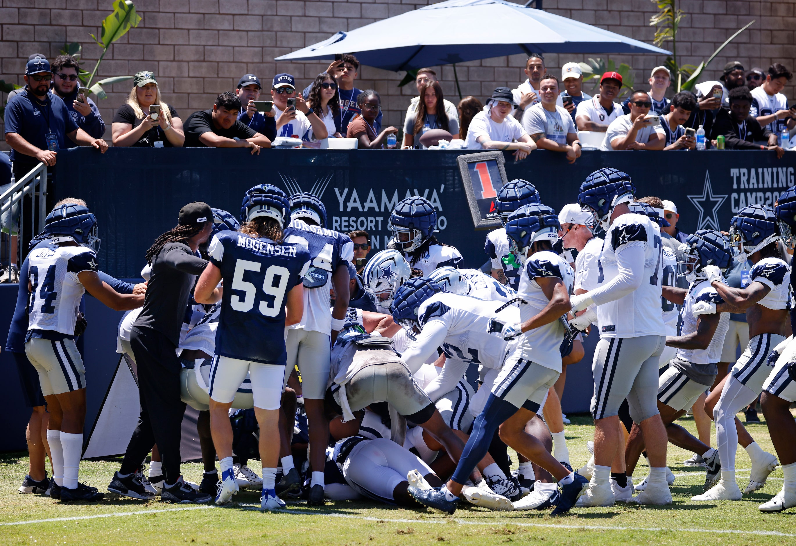 Players and coaches rush in after Dallas Cowboys rookies cornerback Caelen Carson (41, left)...