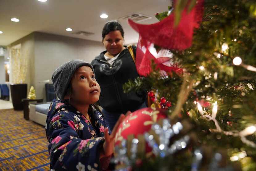Una niña de 7 años observa un árbol de Navidad en el hotel donde ella y su madre, Isabel de...