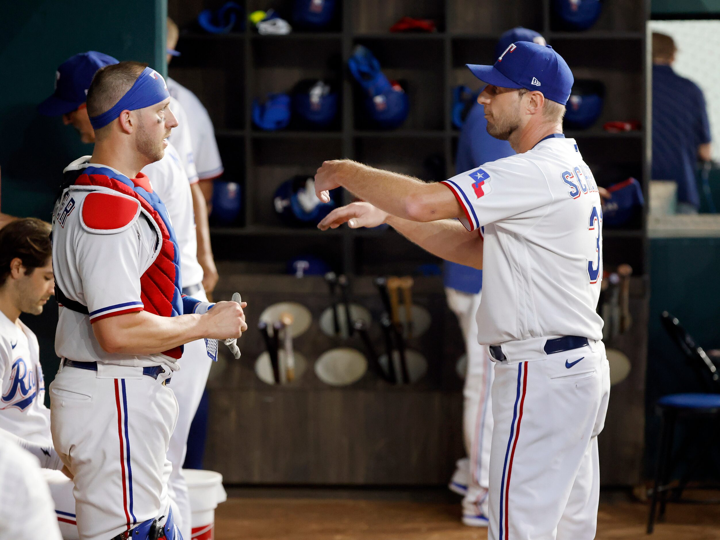 Texas Rangers starting pitcher Max Scherzer (right) and catcher Mitch Garver work through...