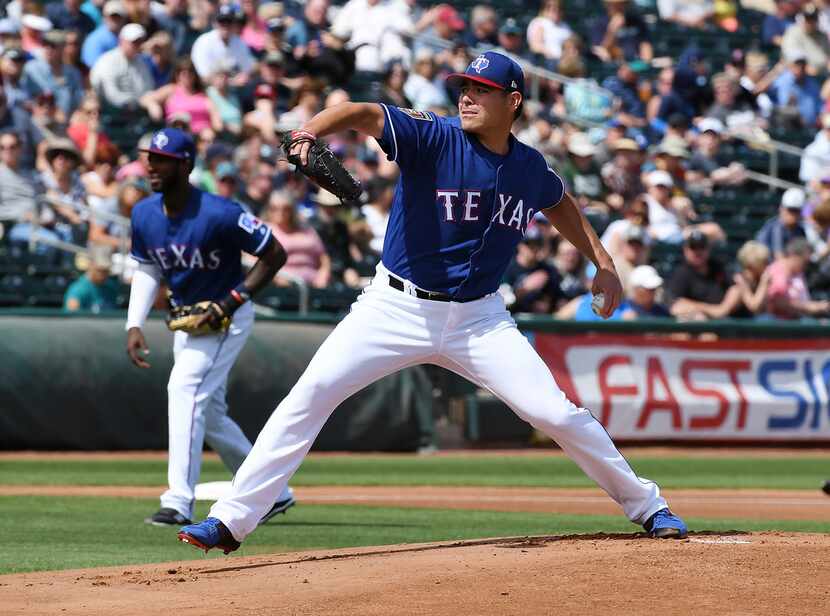 SURPRISE, AZ - MARCH 16:  Matt Moore #55 of the Texas Rangers delivers a first inning pitch...