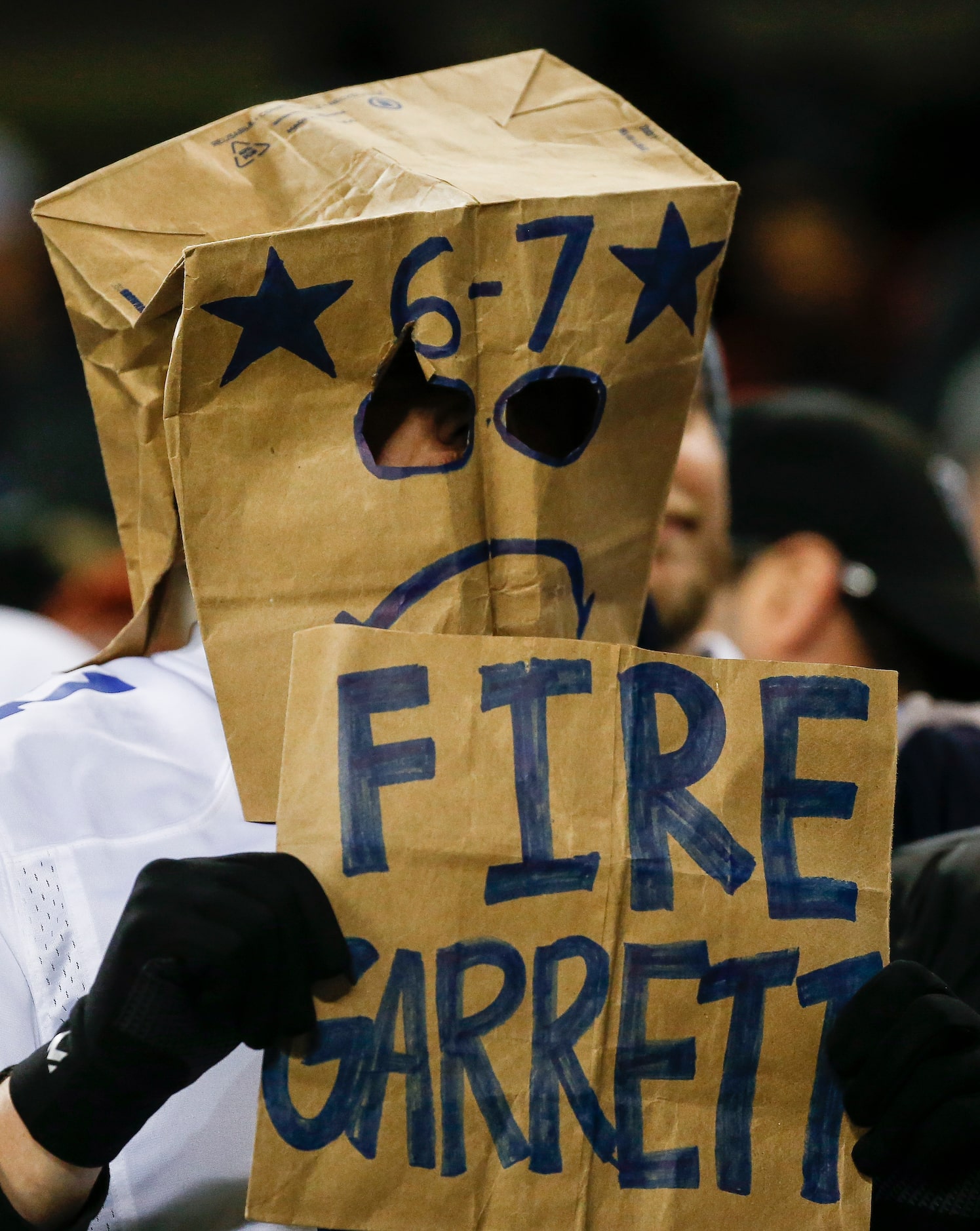 A fan holds a sign calling for the firing of Dallas Cowboys head coach Jason Garrett during...