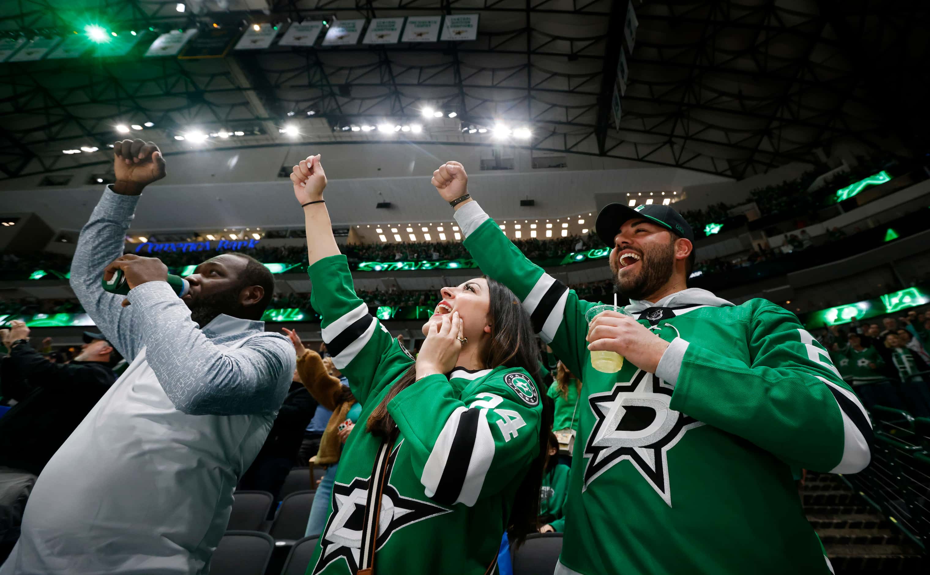 (From left) Michael Aalonia, April McEuen, and David Brooks, all from Dallas, cheer a...
