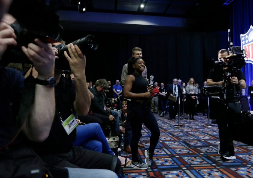 Olympic gymnast Simone Biles asks Lady Gaga a question at a news conference for the NFL...