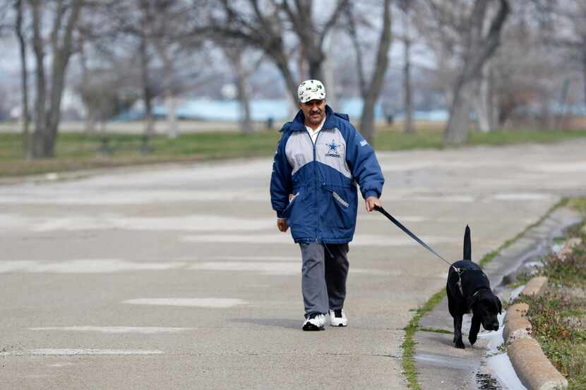 Joaquin Amamaya walks his dog Hero on the south end of Elgin B. Robertson Park at Lake Ray...