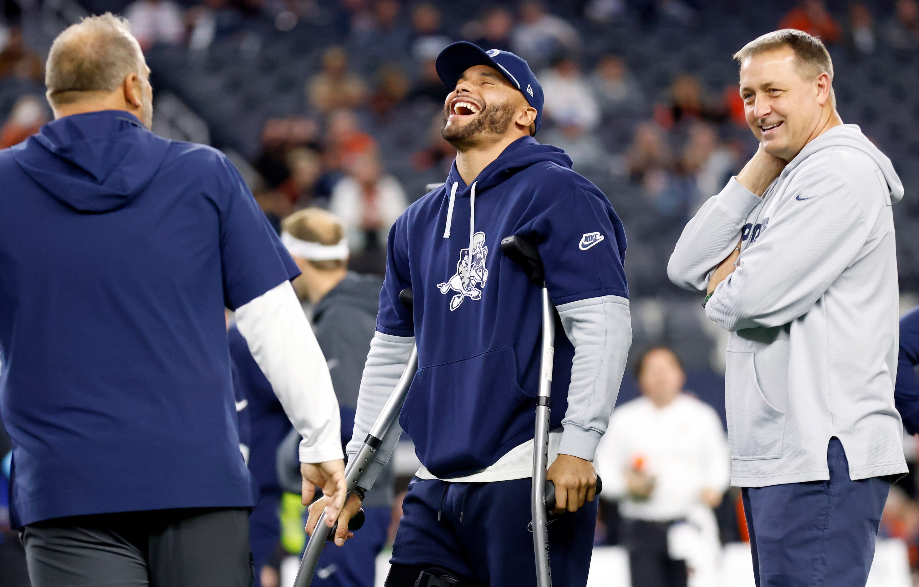 Injured Dallas Cowboys quarterback Dak Prescott (left) uses his crutches to get around ...