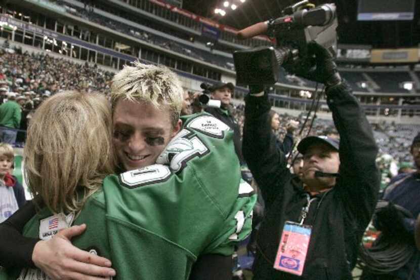 ORG XMIT: *S18BC7E46* A TV crew shoots Southlake Carroll quarterback Greg McElroy as he hugs...