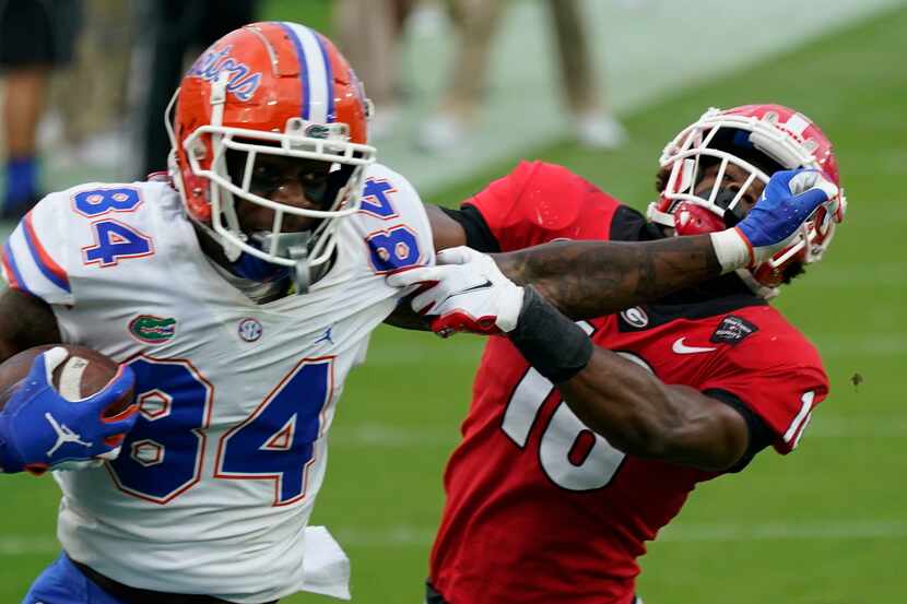 FILE - Florida tight end Kyle Pitts (84) tires to get past Georgia defensive back Lewis Cine...