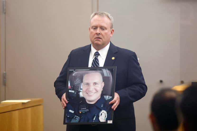 Prosecutor Jason Hermus holds a photo of slain Mesquite police Officer Richard Lee Houston...