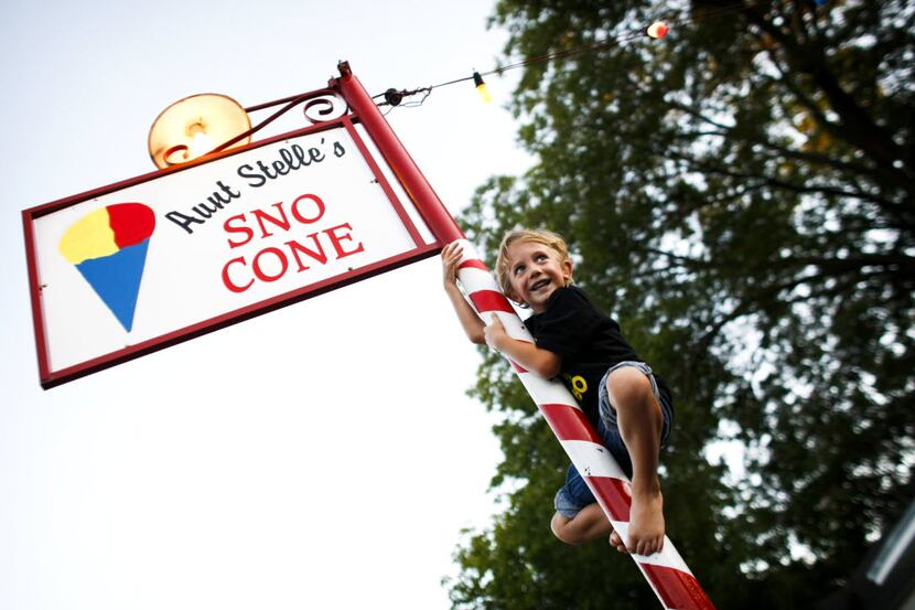 5-year-old, Aidyn Martin, climbs the sign post at Aunt Stelle's Sno Cones, in Oak Cliff,...