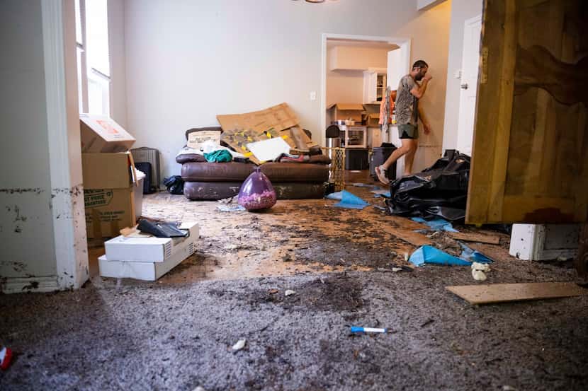 Sean Gallaher walks in his Dallas home damaged by morning floods in August 2022.
