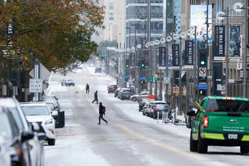 People cross snow covered Main St. on Monday, Jan. 15, 2024 in Dallas. 