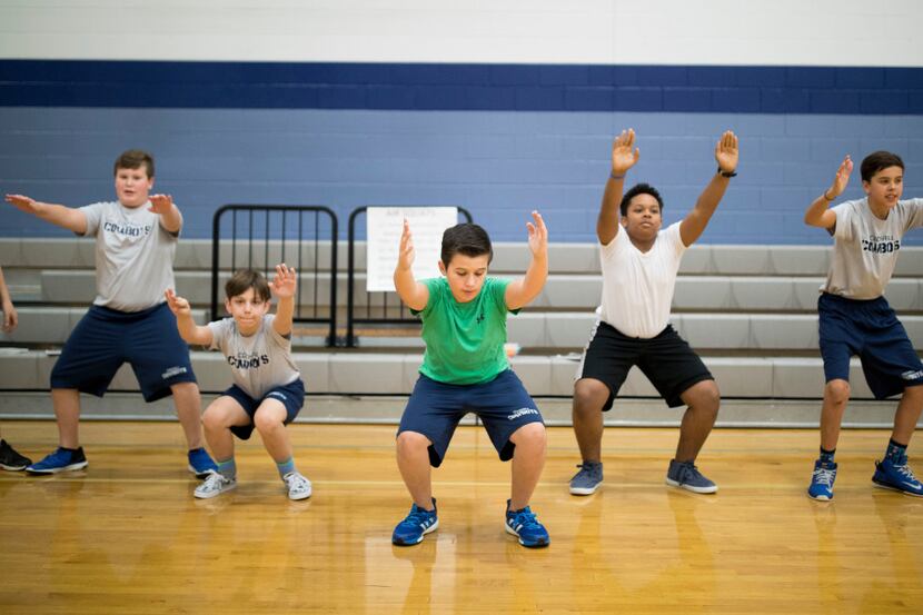 Tyler Siefken (center) does lunges during a seventh-grade PE class at Cockrill Middle School...